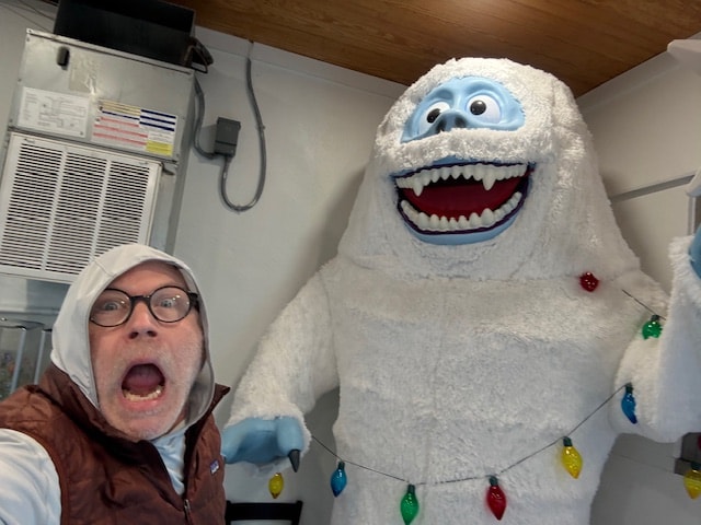 Woman posing with the Abominable Snowman character at a Crystal Coast attraction