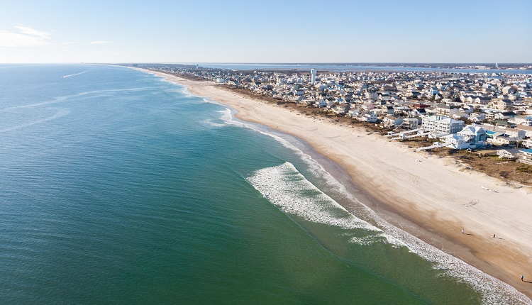 Aerial view of Atlantic Beach NC coastline with ocean waves breaking on white sand and beach houses lining the shore