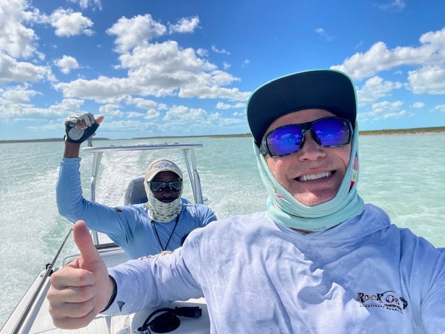 Two guys on the flats boat thumbs up turquoise Andros Bahamas water